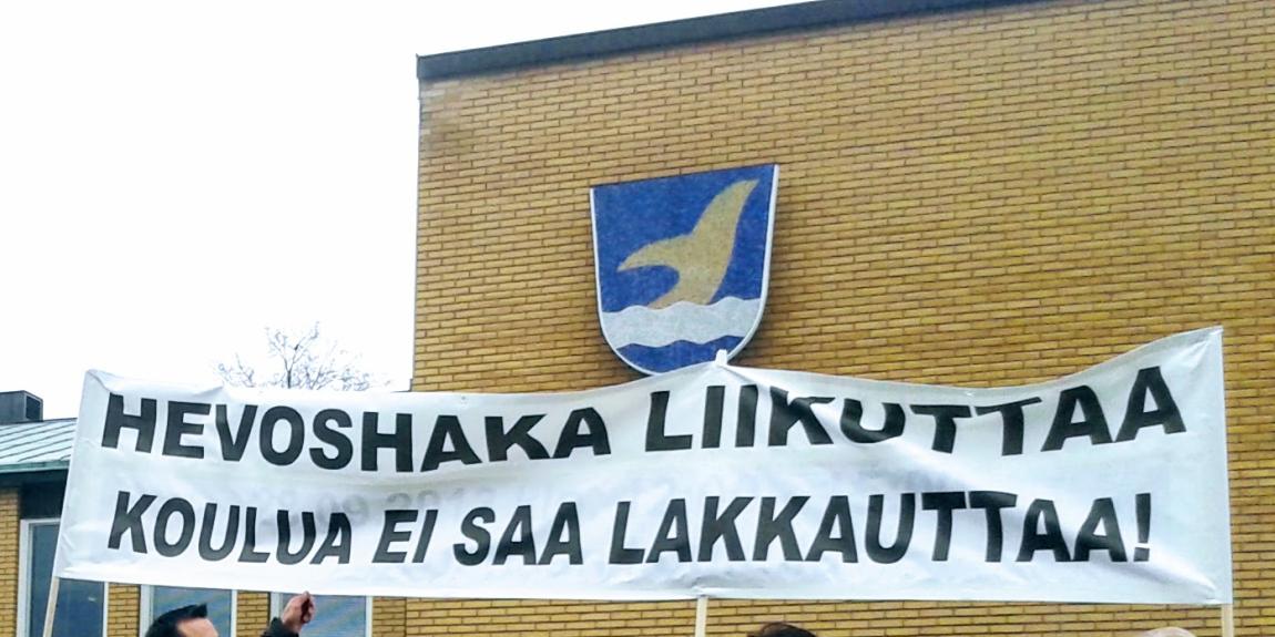 Banderollissa lukee Vantaan kaupungin vaakunan edessä: "Hevoshaka liikuttaa, koulua ei saa lakkauttaa!"