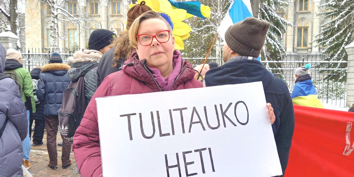 Tiina Sandberg rauhan mielenosoituksessa "Tulitauko heti"-kyltin kanssa.