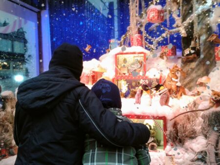 Kaksi lasta katsoo jouluikkunaa.