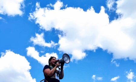 Nainen puhuu megafoniin.