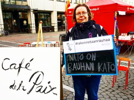 Tiina Sandberg Malmin torilla kyltin kanssa jossa lukee "Nato on rauhan kato".