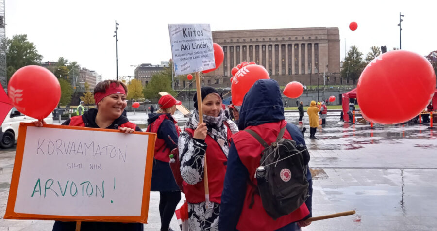 JHL:n jäsenet pitävät mielenosoituksessa kylttiä