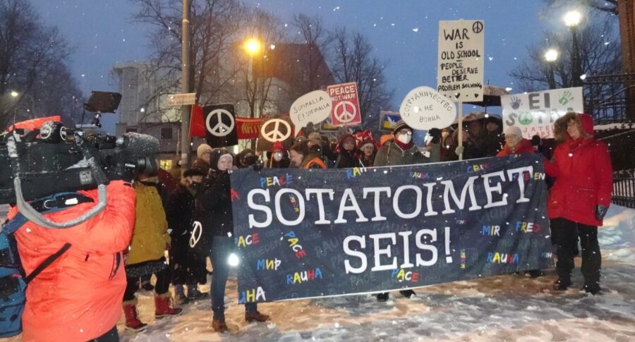 Sotatoimet seis! banderolli mielenosoituksessa.