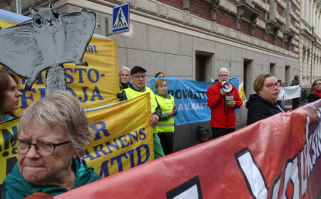 Ihmisiä osoittamassa mieltä erilaisten banderollien kanssa.