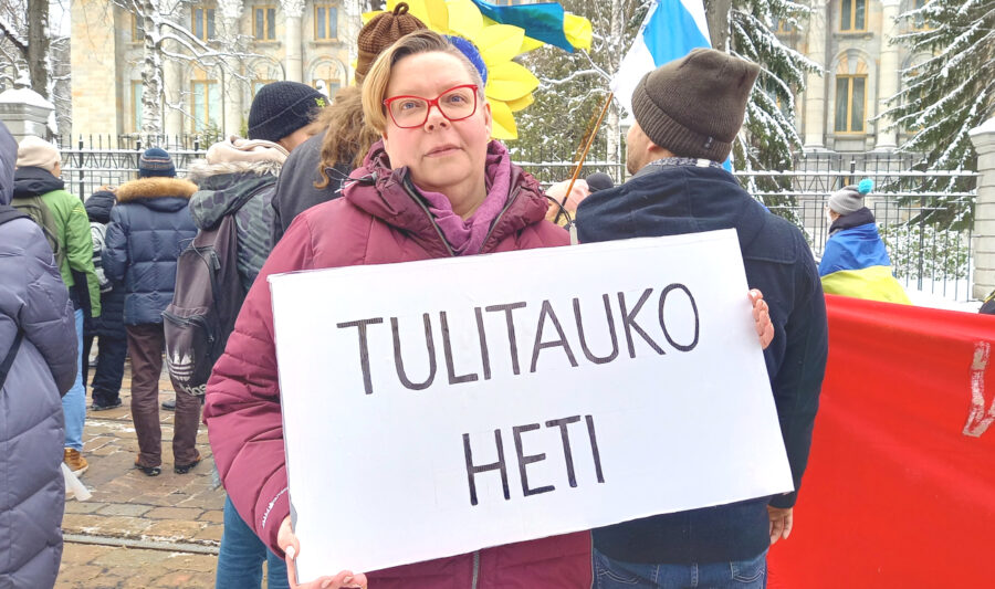 Tiina Sandberg rauhan mielenosoituksessa "Tulitauko heti"-kyltin kanssa.