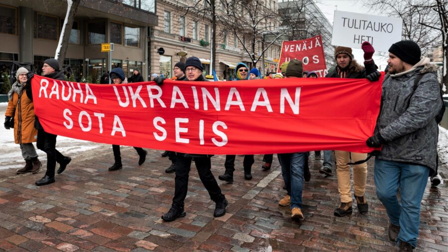 Ihmiset kantavat banderollia